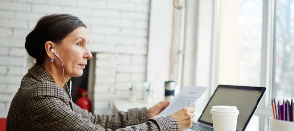 Mature female with document sitting in cafe